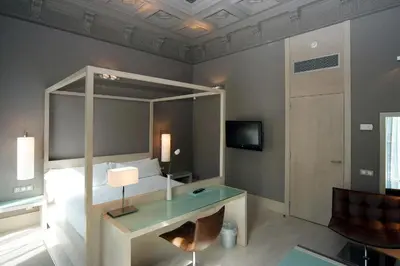 a bedroom with a bed and a desk and a television at Hotel Actual in Barcelona