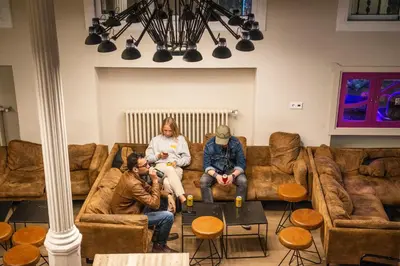 three people sitting on a couch in a living room at Safestay Barcelona Gothic in Barcelona