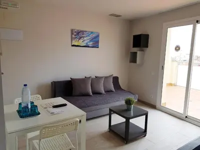 a living room with a couch and a table at Apartamentos Comfort Calella in Calella