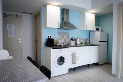a kitchen with a washing machine and a washer at Apartamentos Comfort Calella in Calella