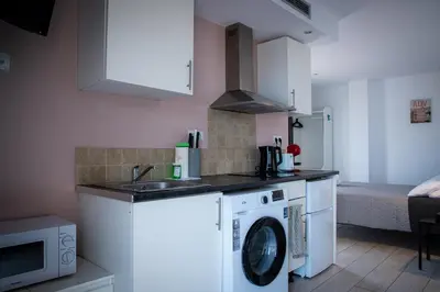 a kitchen with a washing machine and a sink at Apartamentos Comfort Calella in Calella