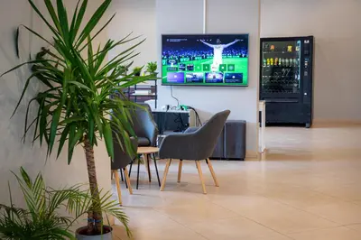 a room with chairs and a tv on a wall at Apartamentos Comfort Calella in Calella