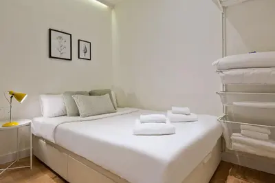 a white bedroom with a bed with towels on it at Urban Chill Apartments by Olala Homes in Hospitalet de Llobregat