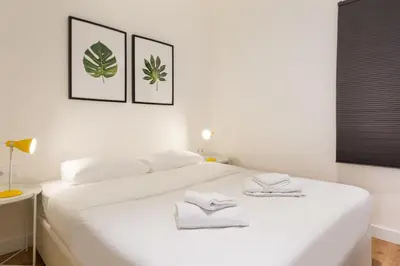 a bedroom with a white bed with towels on it at Urban Chill Apartments by Olala Homes in Hospitalet de Llobregat