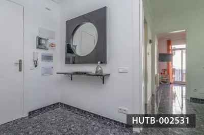 a hallway with a mirror on a white wall at Elegantniy Poble Sec in Barcelona