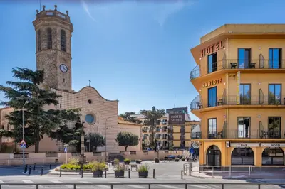 a city with a clock tower and a building at Hotel Sabiote in Pineda de Mar