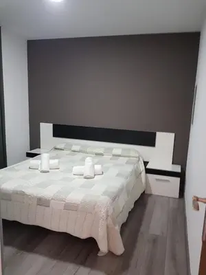 a bedroom with a large white bed with towels on it at Hostal Termes in Sitges