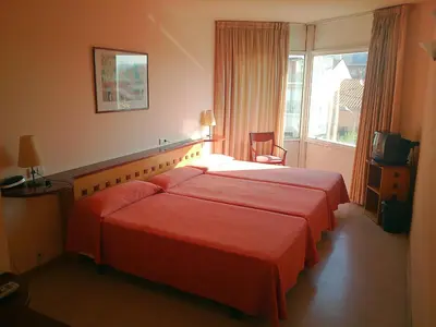 a hotel room with a large bed and a window at Hotel Montmeló in Montmeló