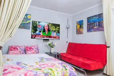 a bedroom with a red bed and a flat screen tv at Camp Nou, Europa Fira - modern two-bedroom apartment with heating in Hospitalet de Llobregat