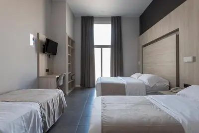 a hotel room with two beds and a television at Plaza Goya Rooms in Barcelona