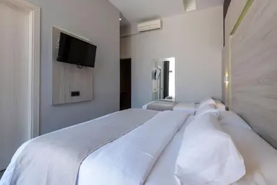 a bedroom with a large white bed with a flat screen tv at Plaza Goya Rooms in Barcelona