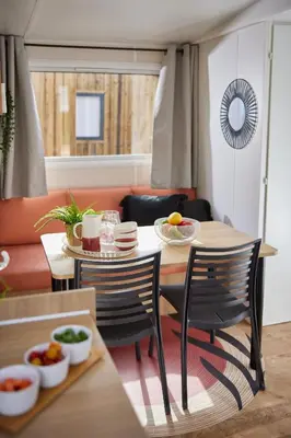a dining room with a table and chairs with food on it at Camping Vilanova Park in Vilanova i la Geltrú