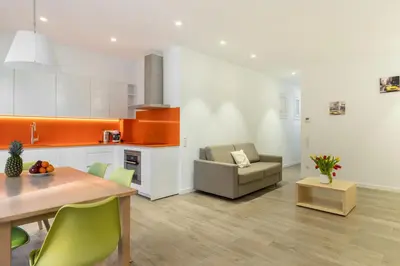 a kitchen and living room with a table and a couch at Cosmo Apartments Marina – Auditori in Barcelona