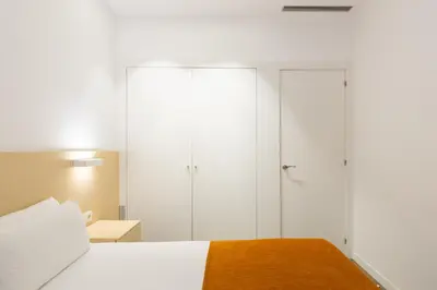 a bedroom with white wardrobes and a bed at Cosmo Apartments Marina – Auditori in Barcelona