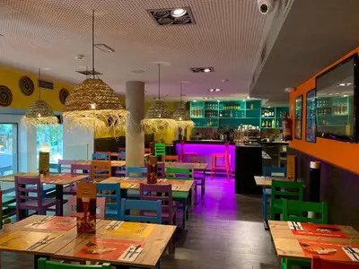 a restaurant with wooden tables and chairs and purple lights at 08028 Apartments in Barcelona