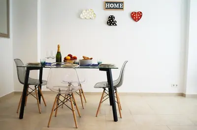a dining room table with chairs and a bottle of wine at Matilda Home on the Beach in Sitges