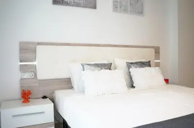 a bedroom with a white bed with two pillows at Matilda Home on the Beach in Sitges