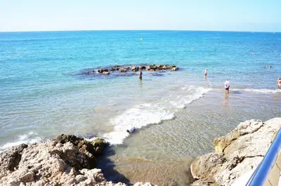 a group of people standing in the water at the beach at Matilda Home on the Beach in Sitges