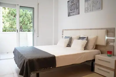 a white bedroom with a large bed with pillows at Matilda Home on the Beach in Sitges