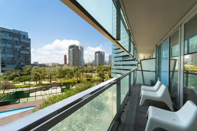 a balcony with two chairs and a view of the city at Unique Rentals-Seafront Luxe Suites in Barcelona