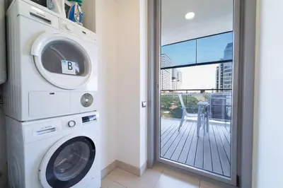 a washer and dryer in a room with a balcony at Unique Rentals-Seafront Luxe Suites in Barcelona
