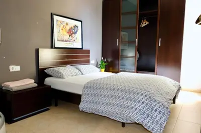 a bedroom with a bed with a wooden head board at Apartment Port Forum in Barcelona