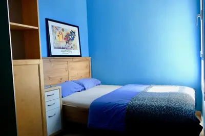 a blue bedroom with a bed and a dresser at Apartment Port Forum in Barcelona