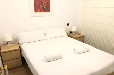 a bedroom with two beds with white sheets and two lamps at NEW! Cute apartment near metro in Barcelona