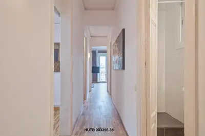 a hallway with white walls and a wooden floor at Alcam Urgell in Barcelona