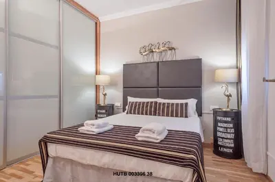 a bedroom with a large bed with two towels on it at Alcam Urgell in Barcelona