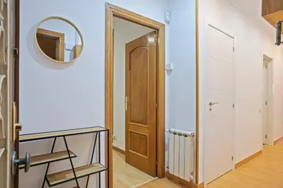 a hallway with a wooden door and a mirror at Alcam Calabria in Barcelona