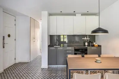 a kitchen with white cabinets and a wooden table at Aspasios Poble Nou Apartments in Barcelona