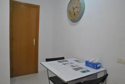a clock on the wall next to a table with a clock at BCN 324 Apartment in Barcelona