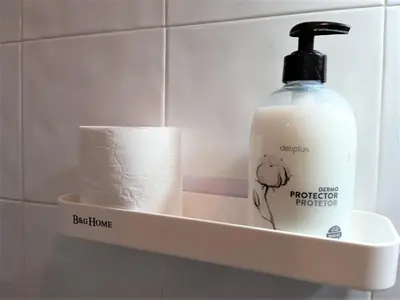 a bathroom shelf with a bottle of soap and a roll of toilet paper at BCN 324 Apartment in Barcelona