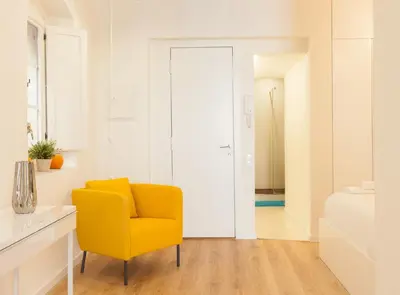 a yellow chair in a white room with a bed at Alsina · Historical center - Barrio Gótico in Barcelona