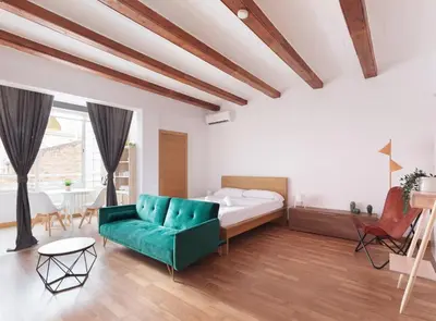 a bedroom with a bed and a green couch at Spacious doubleroom apartment at Sants in Barcelona