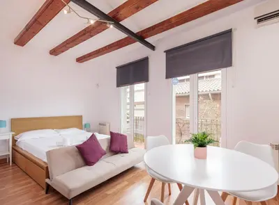 a bedroom with a bed and a white table at Spacious doubleroom apartment at Sants in Barcelona