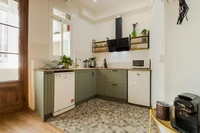 a kitchen with green and white cabinets and a window at Magalhaes · Trad flat in Poble Sec, near ramblas in Barcelona