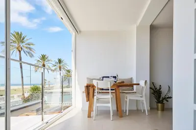 a dining room with a view of the ocean at Sunny Beachfront Escape in Castelldefels