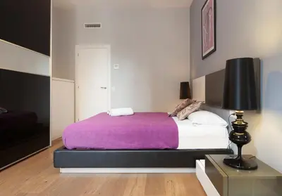 a bedroom with a large bed with a purple blanket at Akira Flats Roger de Flor Chic apartment in Barcelona