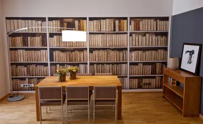 a dining room with a table and chairs in front of a library at Apartments Sixtyfour in Barcelona