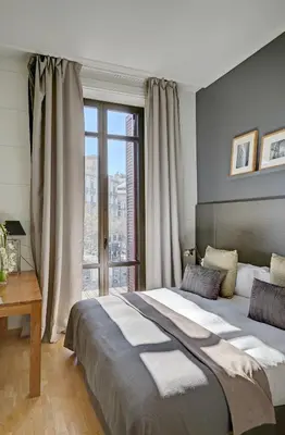 a bedroom with a large bed and a large window at Apartments Sixtyfour in Barcelona