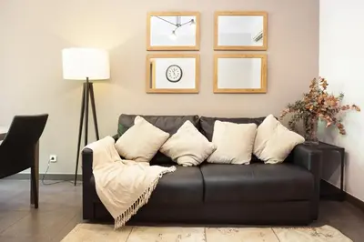 a black couch with pillows in a living room at EasySleep Eixample in Barcelona