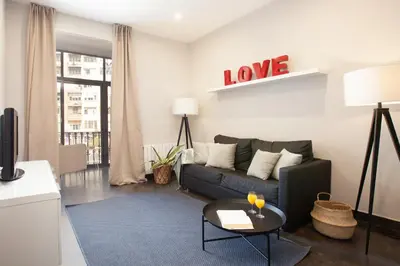 a living room with a couch and a love sign on the wall at EasySleep Gaudi Terrace in Barcelona