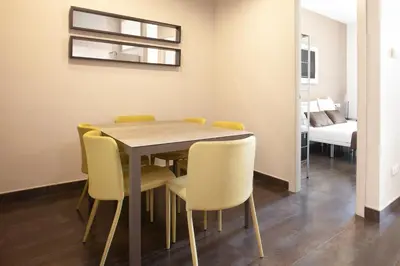 a dining room with a table and yellow chairs at EasySleep Gaudi Terrace in Barcelona