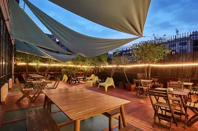 a patio with tables and chairs and lights at Ella Hostel Gran Vía in Barcelona