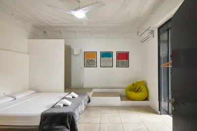 a white room with a bed and a yellow chair at Ella Hostel Gran Vía in Barcelona