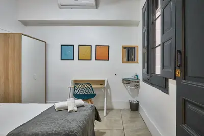 a bedroom with a bed and a desk with a chair at Ella Hostel Gran Vía in Barcelona