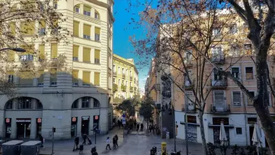 a city street with buildings and people walking on the street at Paraiso Hostel in Barcelona