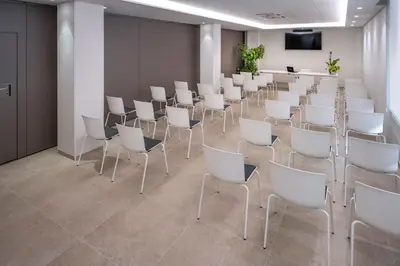 a room with white chairs and a podium at Hotel Mar Blau in Calella